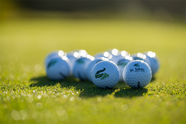 golf balls lying on green reflecting sunshine