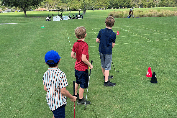 Kids learning to play golf.