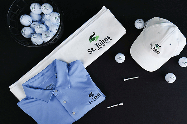 St. Johns Golf Club branded gear is shown on a black table.