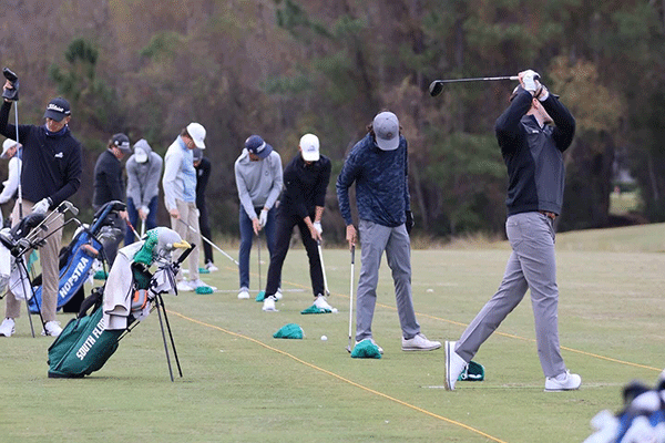 Men playing golf in a row.