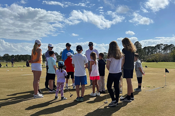Kids listen to instructions during a golf clinic.